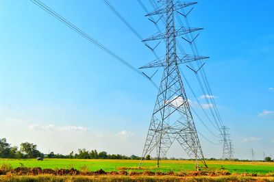 Electricity pylon on field against sky