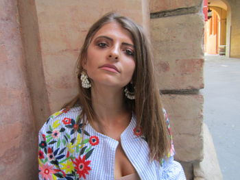Portrait of beautiful woman standing against wall