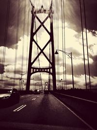 Bridge over river against cloudy sky