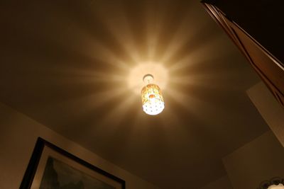 Low angle view of illuminated chandelier hanging from ceiling