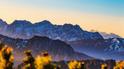 Scenic view of snowcapped mountains against sky during sunset