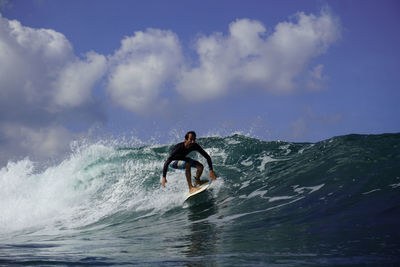 Man surfing in sea against sky