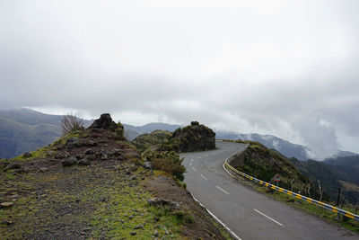 Road leading towards mountain against sky