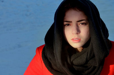Close-up portrait of young woman with headscarf during winter