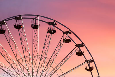 Low angle view of silhouette ferris wheel against sky at sunset