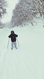 Rear view of person on snow covered field