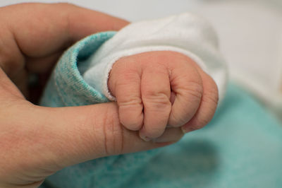 Close-up of mother holding baby hand