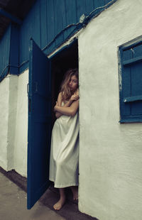 Rear view of woman standing against wall