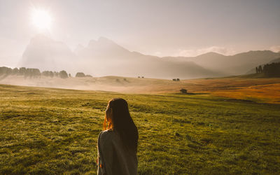 Woman standing on field against sky