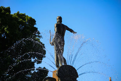 Low angle view of statue against clear blue sky