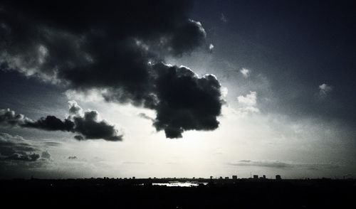 Silhouette of landscape against cloudy sky