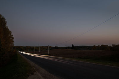 Empty road against sky during sunset