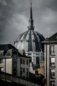View of buildings in city against cloudy sky