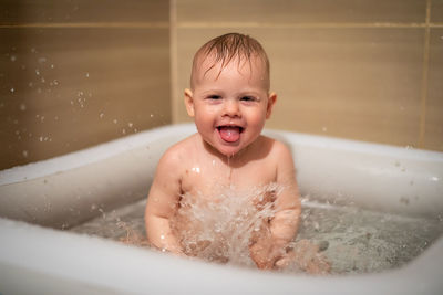 Portrait of cute boy sitting in bath