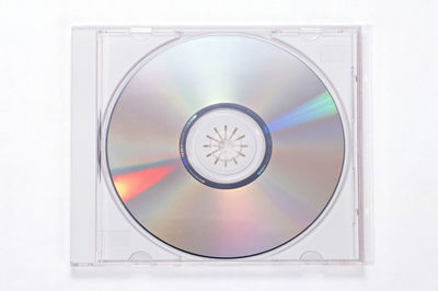 Close-up of compact disc over white background