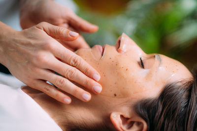 Woman with skincare face mask in beauty salon