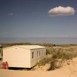 View of beach against sky with caravan and sand dunes in cornwall single cloud blue sky summer