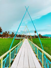 Empty footbridge against sky