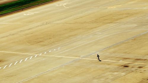 Aerial view of person walking on airport runway
