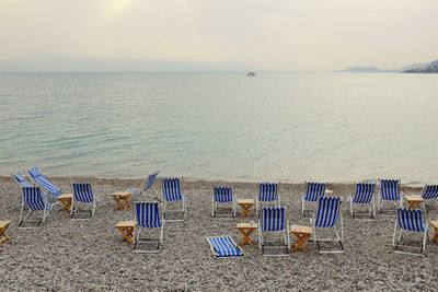 Chairs on beach against sky