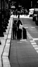 Rear view of people walking on street