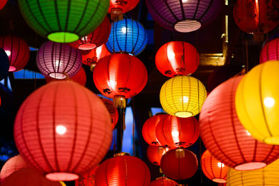 Low angle view of illuminated lanterns hanging at night