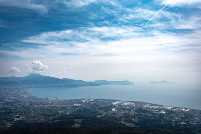 Aerial view of land by sea against sky