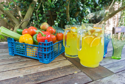 Close-up of drink by vegetables in crate