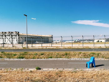 View of empty road on field against blue sky