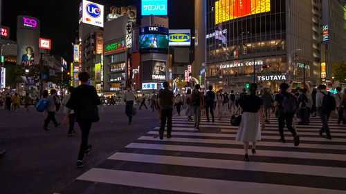 Group of people crossing road at night