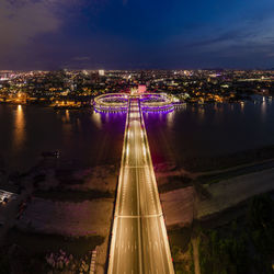 High angle view of illuminated bridge over river against sky at night