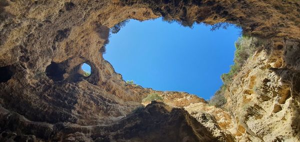 Low angle view of rock formation against clear blue sky