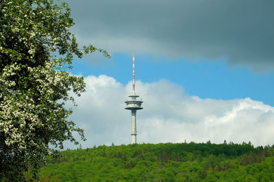 Communications tower against cloudy sky