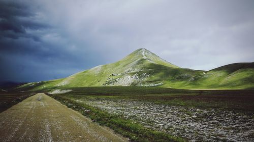 Road amidst field against sky
