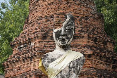 Low angle view of old damaged buddha statue and temple