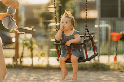 Full length of boy swinging at playground