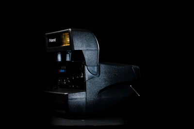 Close-up of camera on table against black background