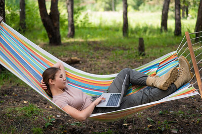 Low section of woman sitting on hammock