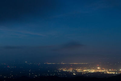 Illuminated cityscape against sky at night
