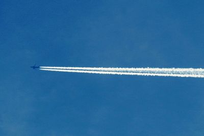 Low angle view of vapor trail against blue sky