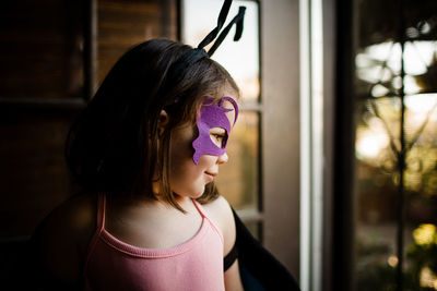 Young girl in dress up looking out front door