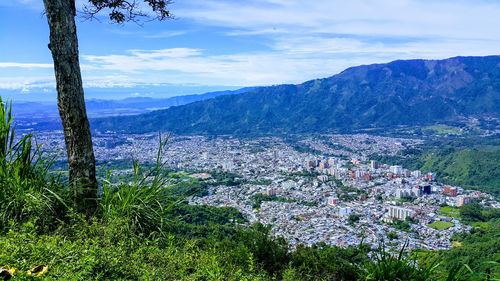 Aerial view of townscape and mountains against sky