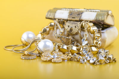 Close-up of jewelry and box against yellow background