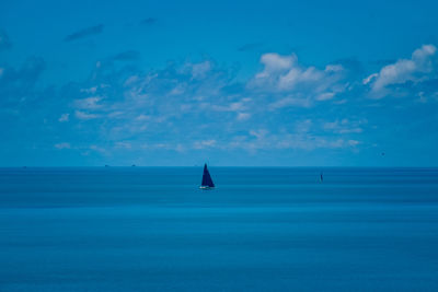 Sailboat in sea against blue sky