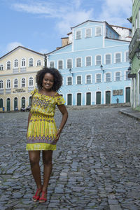 Portrait of woman standing against building