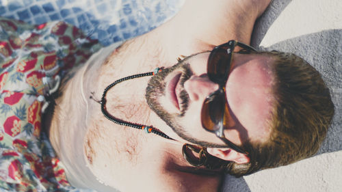 Portrait of shirtless wearing sunglasses at beach