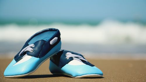 Close-up of shoes on beach