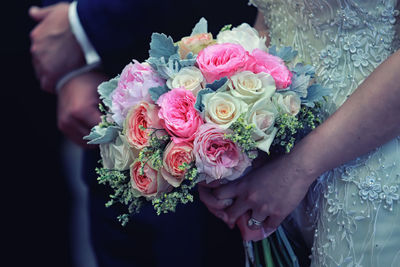 Midsection of woman holding rose bouquet