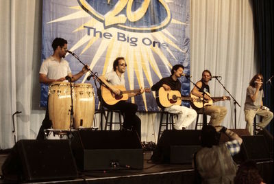 People playing guitar at music concert