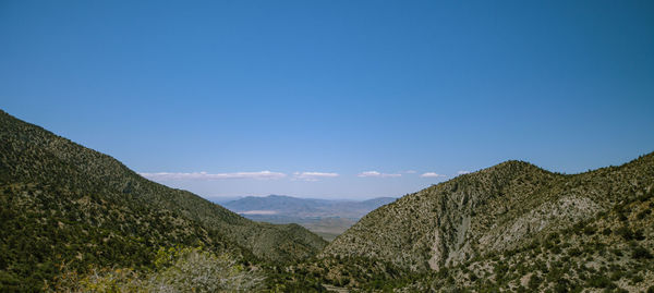 Scenic view of mountains against clear blue sky